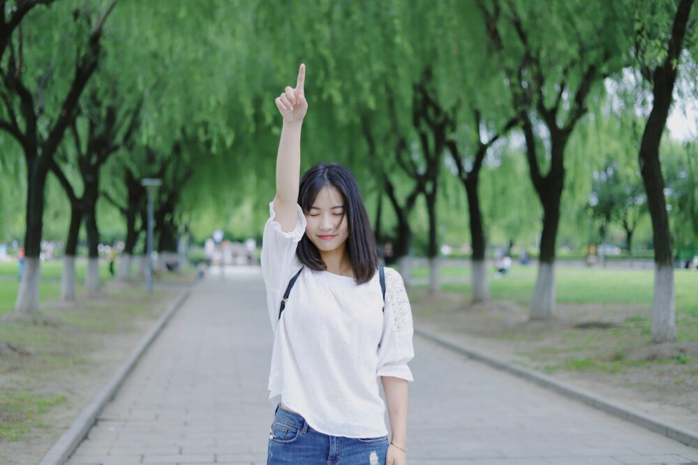 空を指差す女性